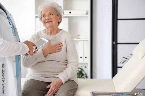 Ill senior woman talking to...
