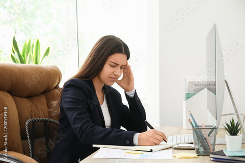 Young woman writing on note...