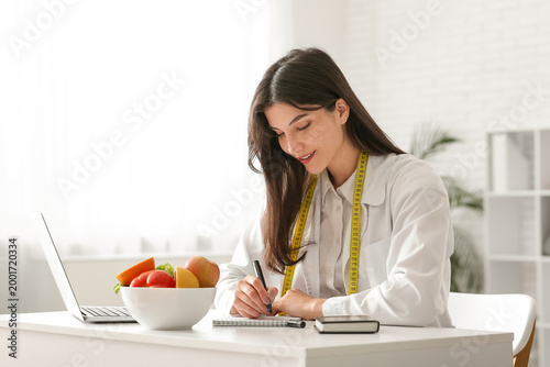 Female nutritionist writing...