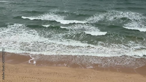 Ocean waves rolling onto sandy shore captured 