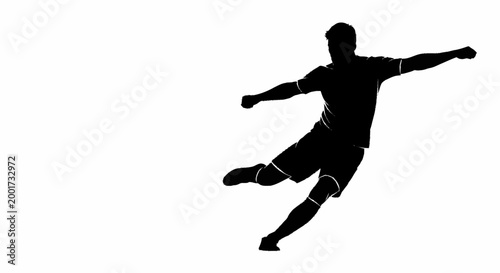 Silhouette of a soccer player kicking a ball