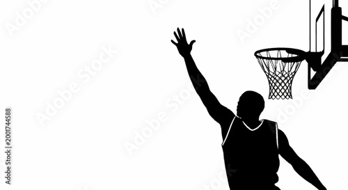 Silhouette of a basketball player reaching for the hoop