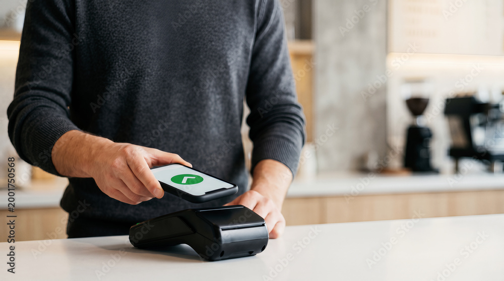 Fototapeta premium Contactless mobile payment with smartphone at cafe counter