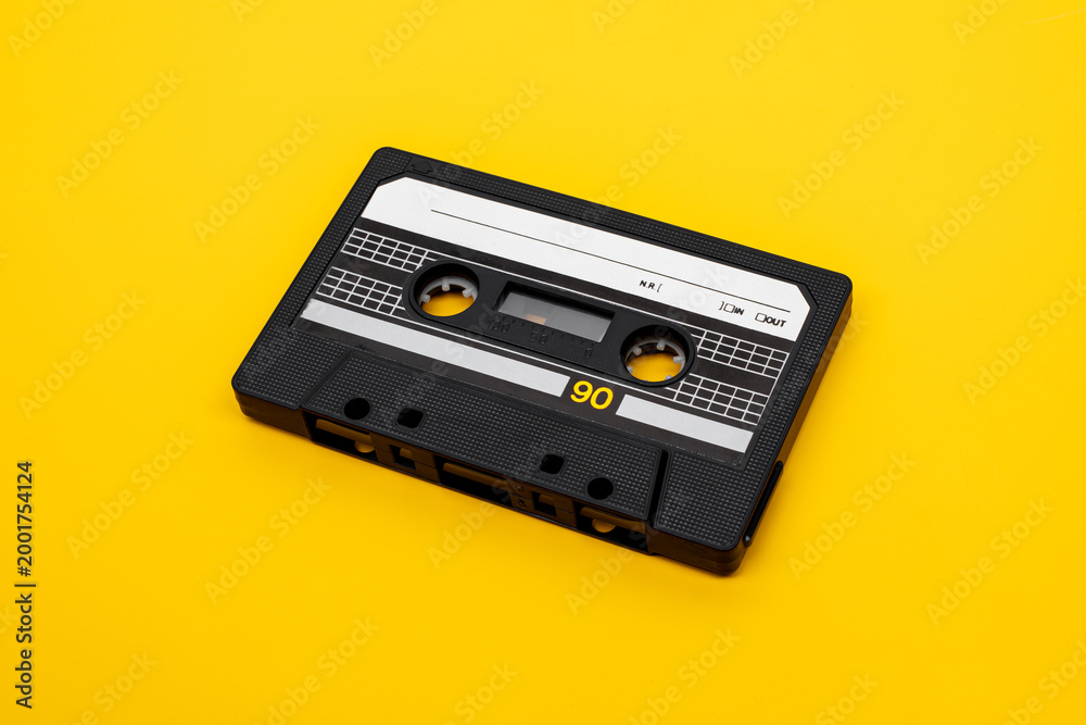 Fototapeta premium Black audio cassette on yellow background