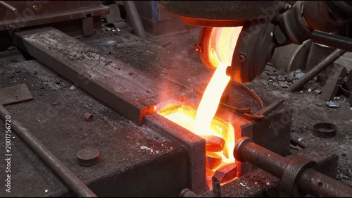Liquid iron molten metal pouring in container, industrial metallurgical factory, foundry cast, heavy industry background.
