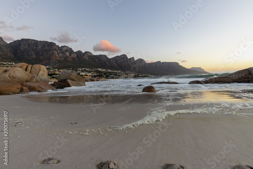Sunset with splashing water at Maiden's Cove, a beautiful stretch of sandy beach between  Clifton and Glen Beach, with amazing views on the absolutely breath-taking Twelve Apostles Mountain Range The 