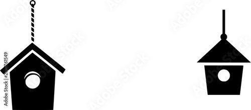 A rustic vintage birdhouse hangs from a twisted rope against a serene backdrop of greenery and blooming flowers