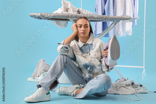 Tired young woman with iron...