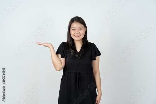 Smiling Asian woman holding open palm for product placement isolated on white background