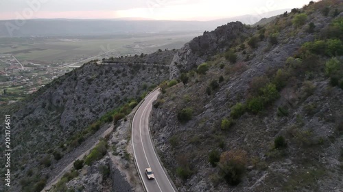 Aerial view of cars driving along a winding mountain road.