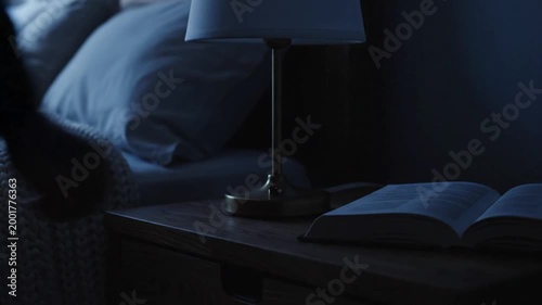 Person turning off bedside lamp.