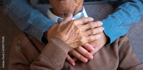 Bilde på lerret A close-up image of a caregiver's hands comforting an elderly man in a home-based care facility reflects the concept of caring for and assisting the elderly