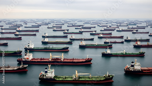 Large Fleet of Cargo Ships and Oil Tankers Anchored at Sea