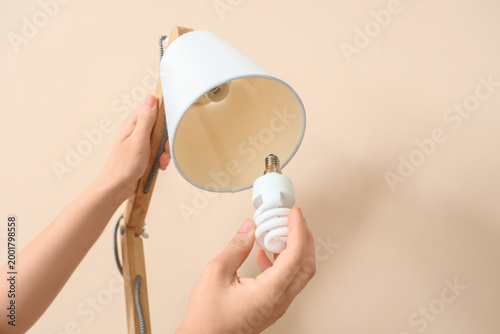 Woman changing light bulb i...