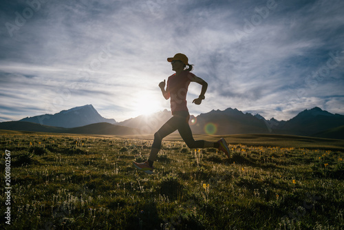 Trail runner running on the high altitude grassland mountain top