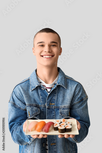 Young man with tasty sushi ...