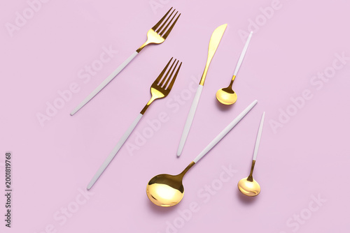 Stylish cutlery on pink bac...
