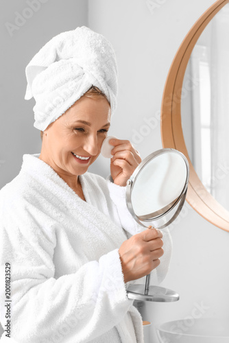 Mature woman applying cosme...