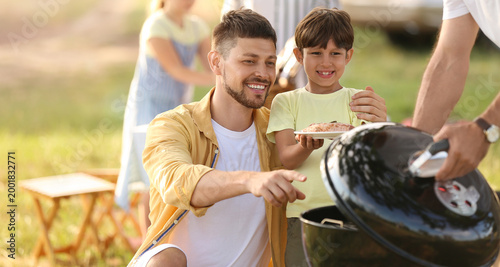 Foto Happy family at barbecue party on summer day