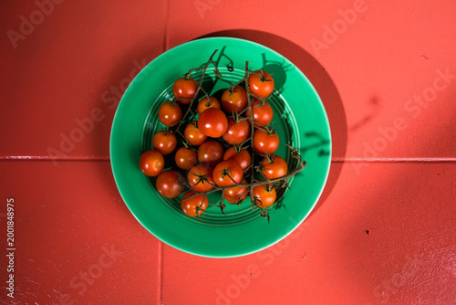 Tiny cherry tomatoes ciliegini, pachino, cocktail. group of cherry tomatoes on a color concrete background.