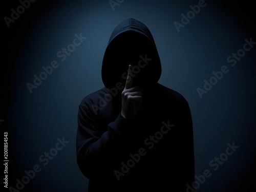 Person in a dark hoodie making a shushing gesture against a dark blue background