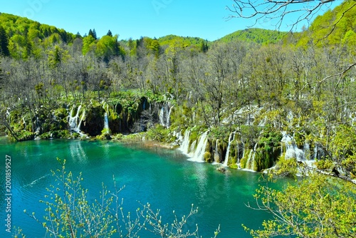 Foto Beautiful waterfall cascade flowing into a lake in Plitvice national park, Lika,