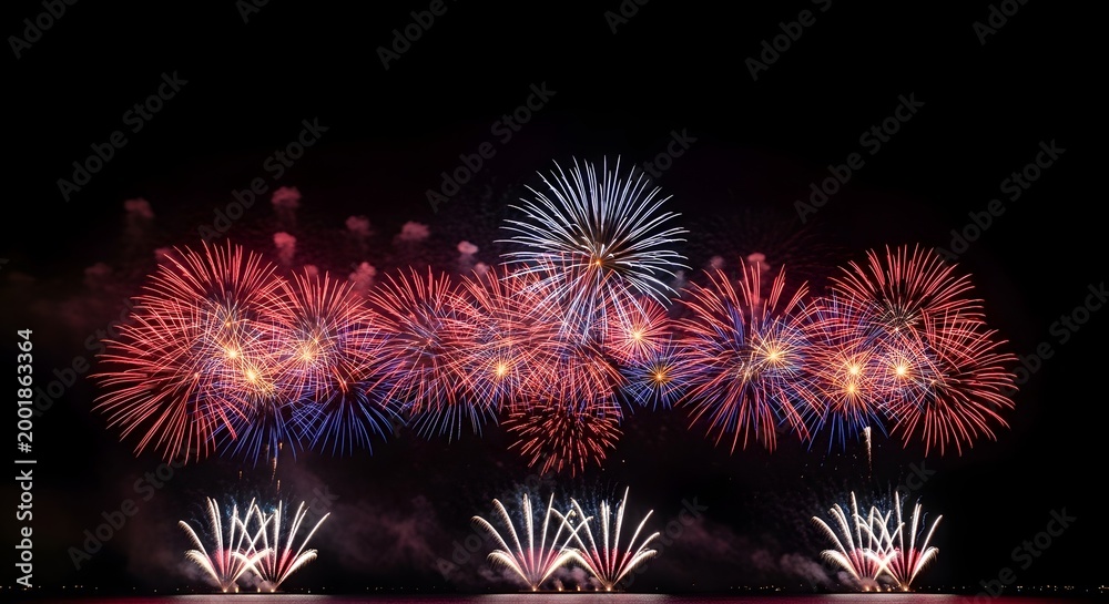Fototapeta premium Vibrant fireworks display on 4th of July celebration at night with red white and blue colors lighting up the sky