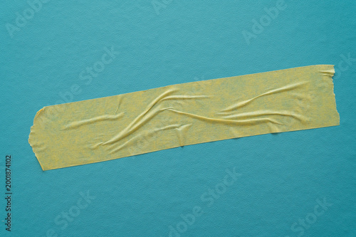 Folded adhesive tapes on a light blue background, minimal graphic texture with contrasts.