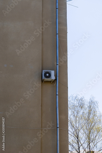 air conditioner, condenser unit, compressor on facade of building. unit of central AC conditioner of HVAC heating ventilation system. Indoor and office air cooling during seasonal temperature rise.