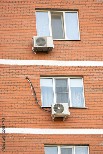 air conditioner, condenser unit, compressor on facade of building. unit of central AC conditioner of HVAC heating ventilation system. Indoor and office air cooling during seasonal temperature rise.