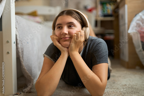 Teen girl lying on floor listening to music