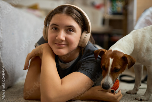 Teen girl relaxing with dog and toy