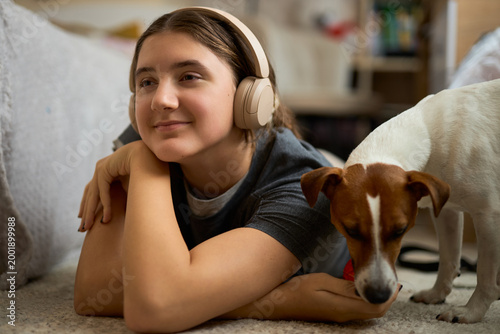 Teen girl relaxing with dog and toy