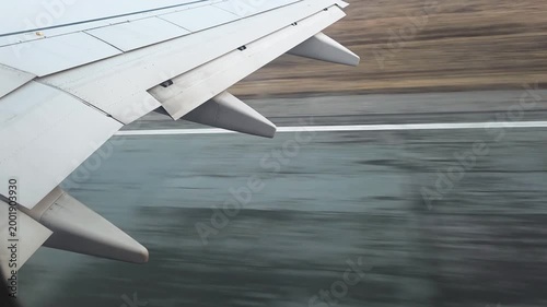 Airplane wing with flaps extending, moving swiftly along the tarmac, capturing the dynamic moment before flying and symbolizing ready for travel or journey