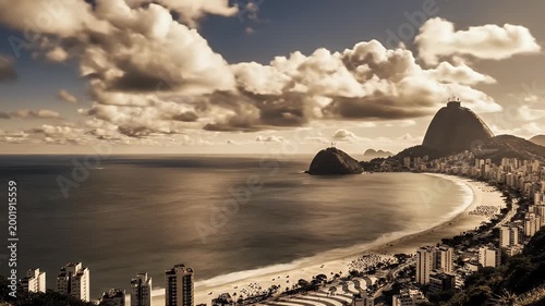 A stunning panoramic view showcases the iconic Christ the Redeemer statue overlooking the sprawling cityscape and beautiful beach of Rio de Janeiro, Brazil, under a dramatic cloudy sky.