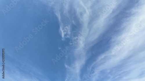 Pale blue sky with wispy white cloud slow pan.