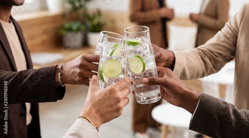 Cheers! An intimate moment of connection, captured as a convivial gathering raises glasses filled with effervescent drinks. A toast of unity and camaraderie among colleagues.