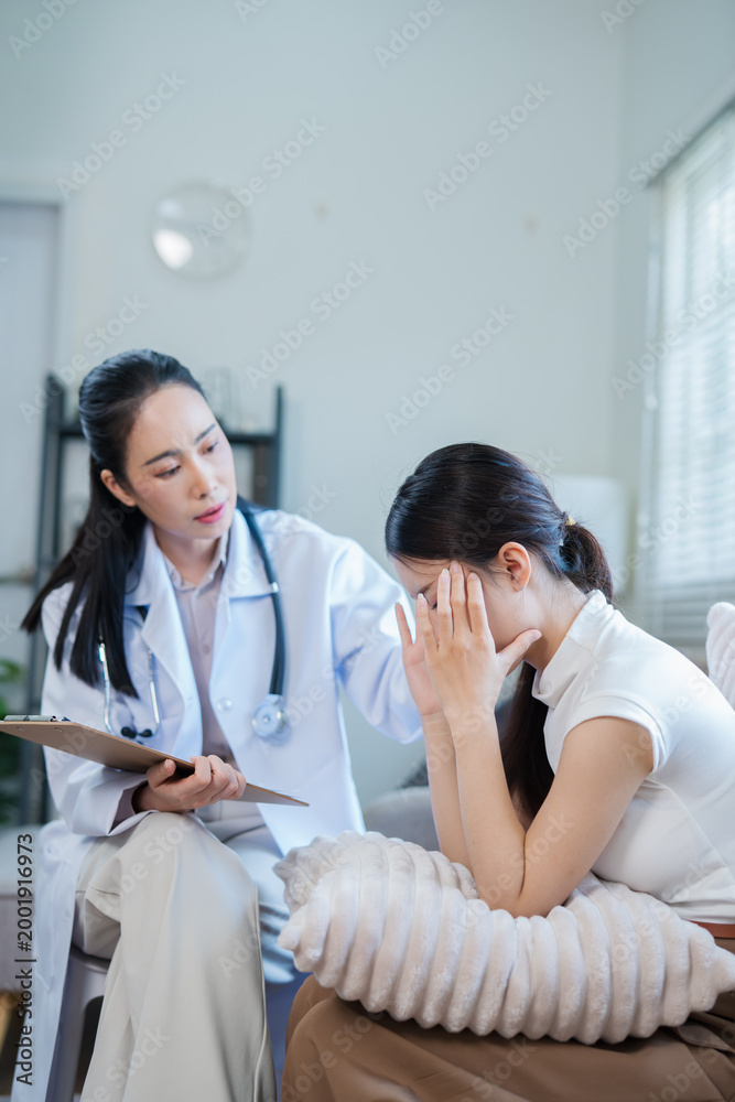 Fototapeta premium A doctor or nurse is talking to a patient sitting on a sofa in a private hospital room.