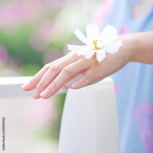 Woman hand gently holding a single white cosmos flower, soft natural lighting, serene atmosphere, beauty, wellness, tenderness, floral elegance
