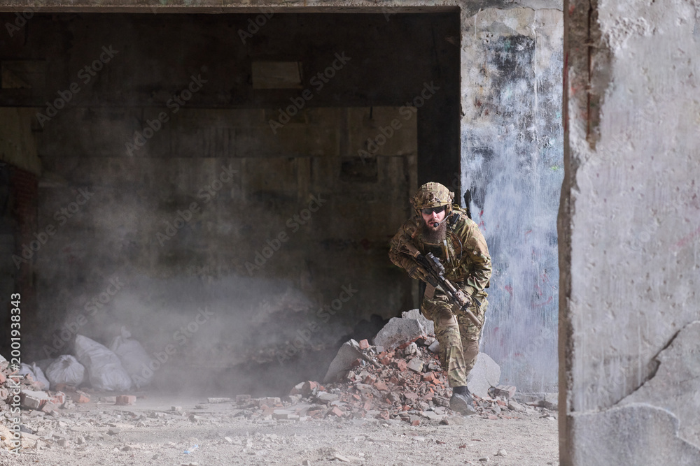 Fototapeta premium Soldier In Tactical Gear Moving Through Urban Ruins With Rifle During Combat Training Operation