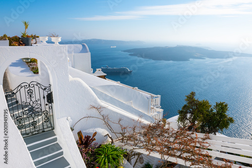 White architecture in Santorini island, Greece. Beautiful terrace with flowers. Sea view at sunny day.