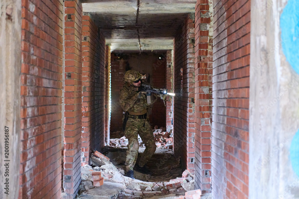 Obraz premium Tactical Soldier With Rifle Clearing A Rubble-Filled Urban Corridor During Training Operation