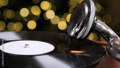 Картината върху платно Close up of a vintage gramophone stylus tracing a spinning vinyl record, warm go