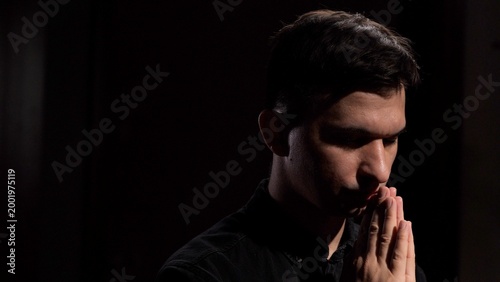 Bilde på lerret Man with head bowed, expressing devotion and spirituality through prayer and con