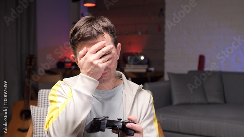 Bild auf Leinwand Unhappy gamer man experiencing disappointment and frustration while playing a vi