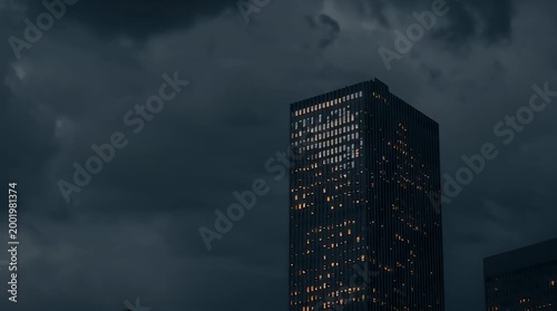 Towering skyscraper against dramatic cloudy sky at dusk