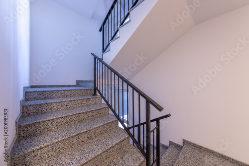 Modern stair case between floors. Stairs with metallic rail in modern building. Interior of a contemporary apartment or office building. Architecture and real estate background.