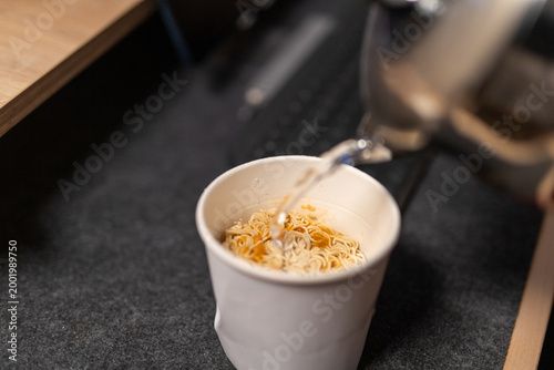 Close-up of pouring hot water into an instant noodle box