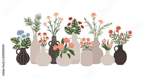 Variety of colorful flowers and green plants in different shaped ceramic vases arranged in a decorative row against a white background.