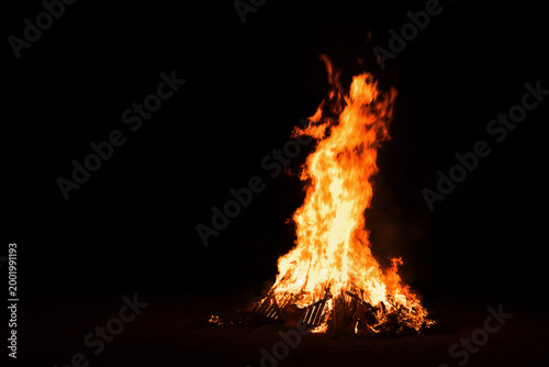 Konstfotografi A tall bonfire is lit outdoors at night to celebrate the summer solstice - Līgo